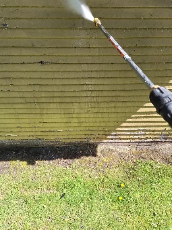 A pressure-washing wand cleaning exterior siding in LLN’s published gallery