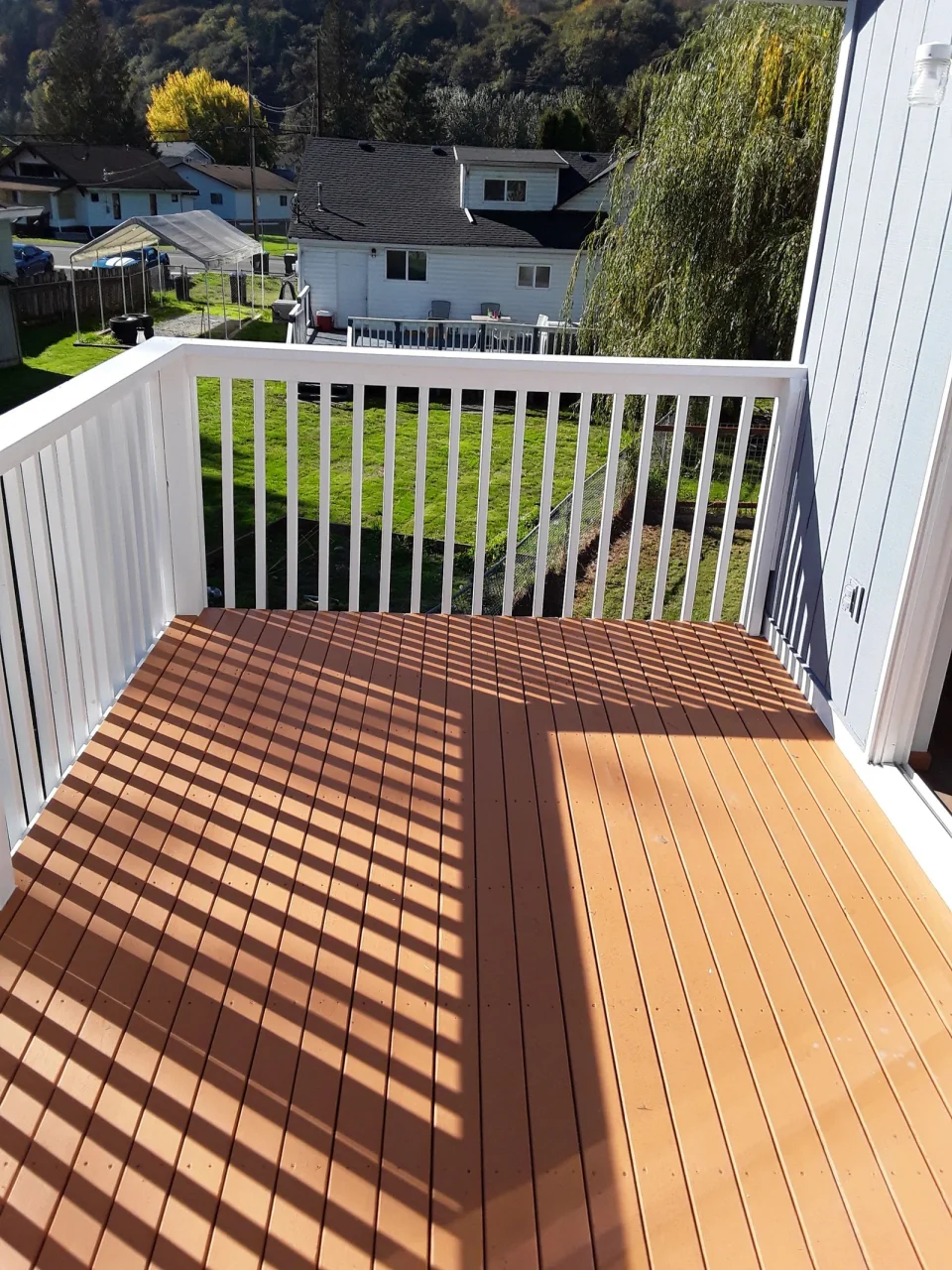 Warm brown deck boards and white railings in LLN’s published gallery